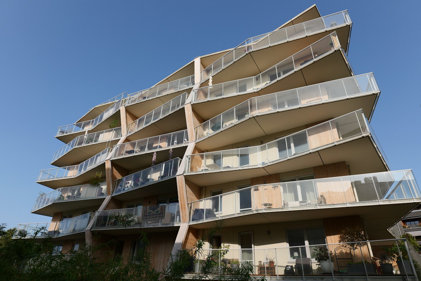 Moderno condominio con balconi curvi e posti a sedere all'aperto.